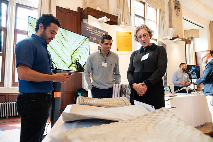 U-M students and faculty look at exhibits on a table at the Michigan Union